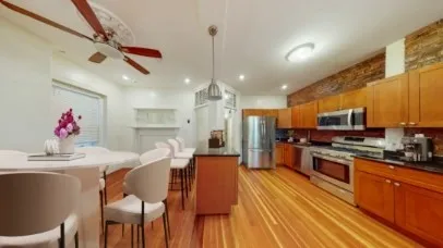 a kitchen with stainless steel appliances kitchen island granite countertop a stove a sink dishwasher and a refrigerator with wooden floor