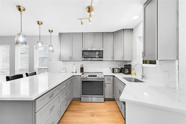 a kitchen with a sink a stove and cabinets