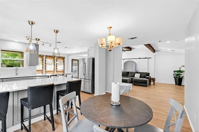 a dining table chairs and a chandelier