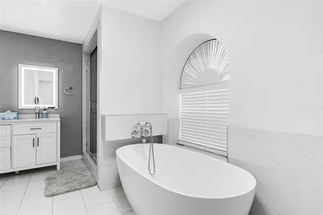 a bathroom with a sink a bathtub and a mirror