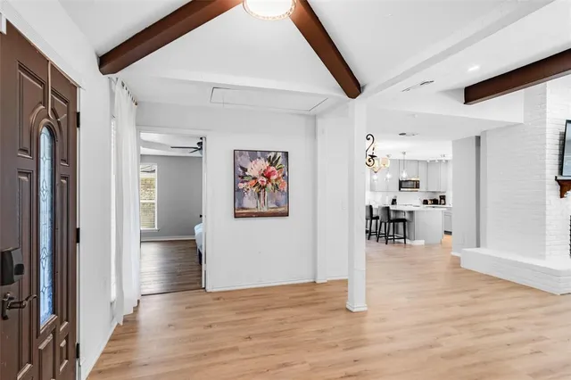 a view of a hallway with wooden floor and furniture