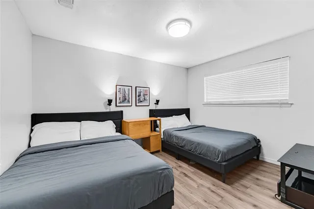 a bedroom with two beds and painting on the wall