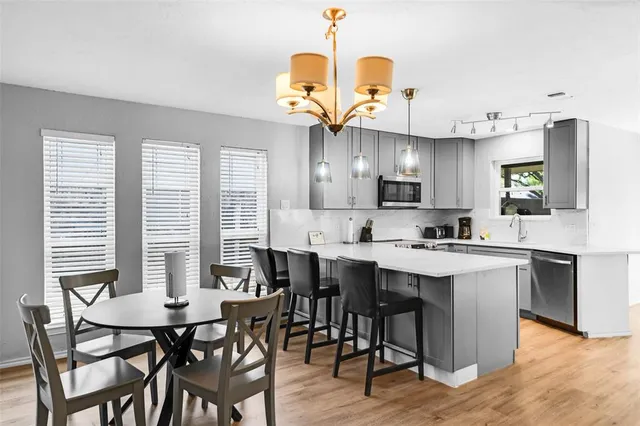 a kitchen with cabinets a sink dining table and chairs