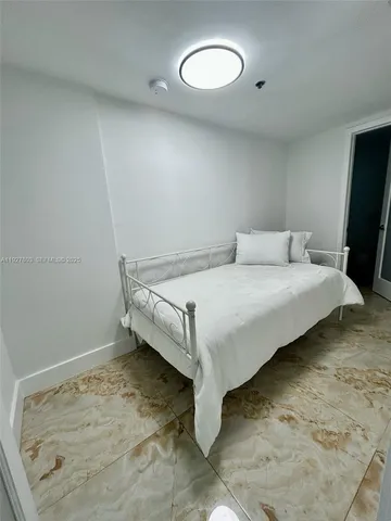 a bedroom with a bed and a flat tv screen on a dresser
