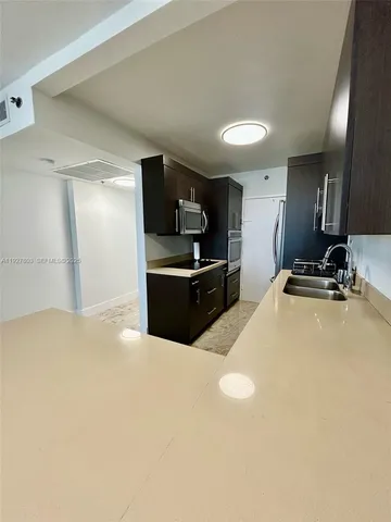a kitchen with kitchen island a sink stainless steel appliances and cabinets