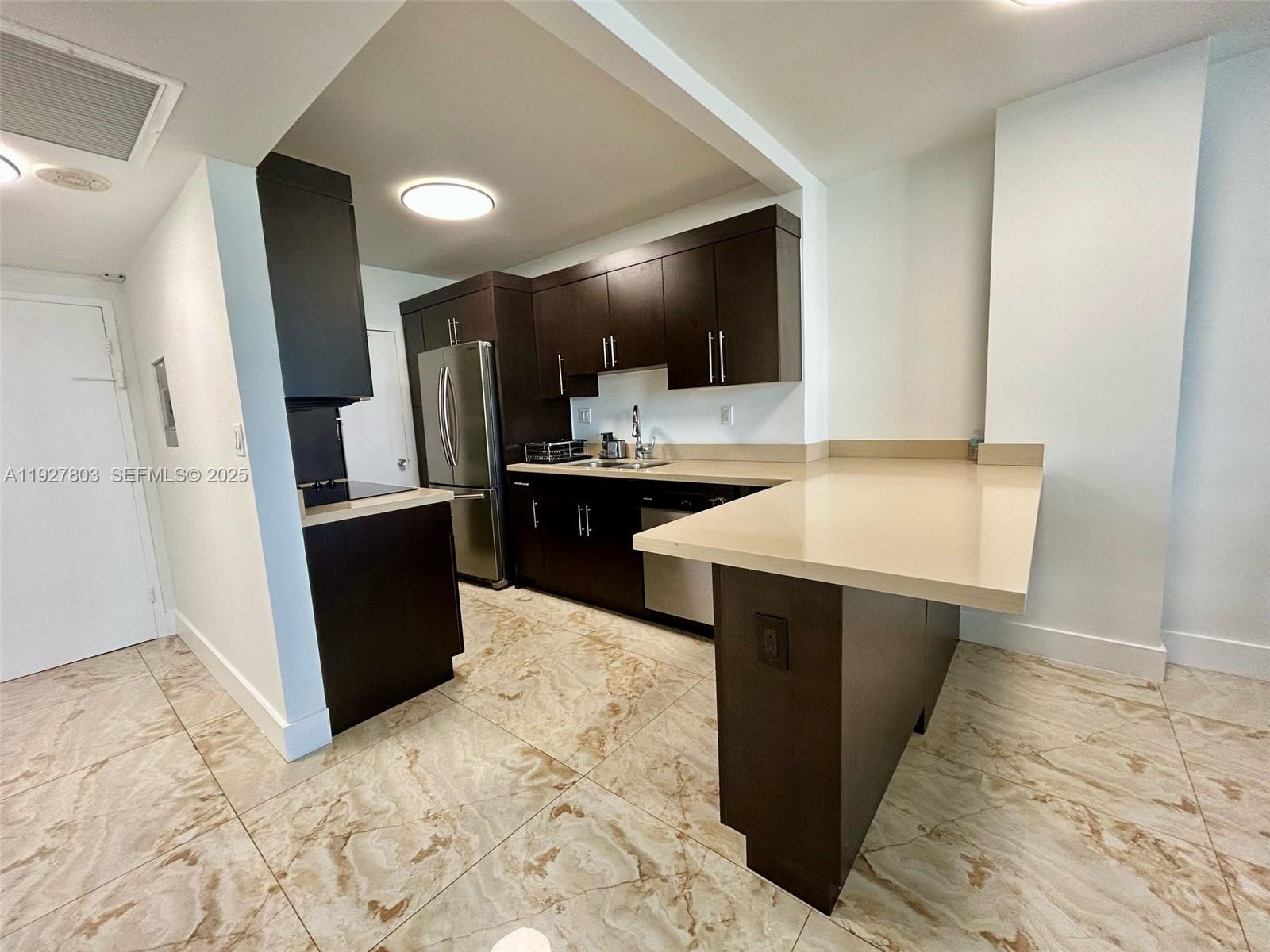 100 Lincoln Road, Unit 722 Miami Beach, FL 33139 - Photo 6 of 17 a kitchen with stainless steel appliances kitchen island granite countertop a sink and cabinets