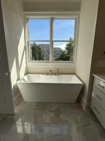 a bathroom with a bathtub and window