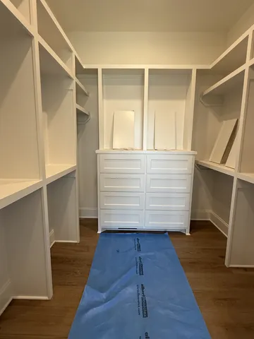 a view of walk in closet with empty racks