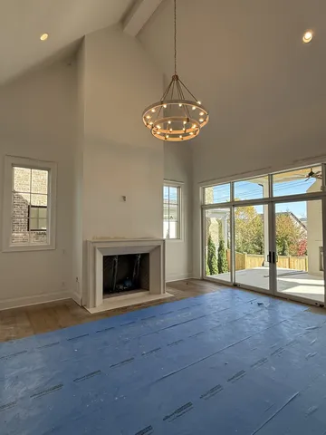 a view of an empty room with a fireplace and a window