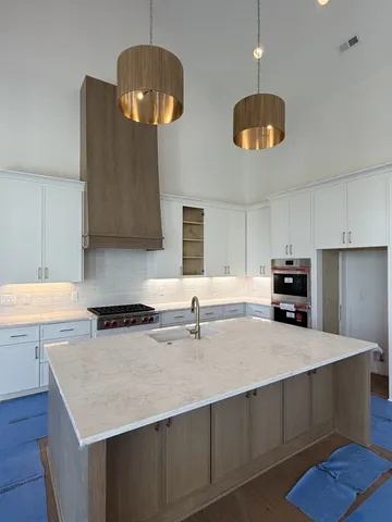 a kitchen with stainless steel appliances granite countertop a sink a stove a refrigerator and cabinets