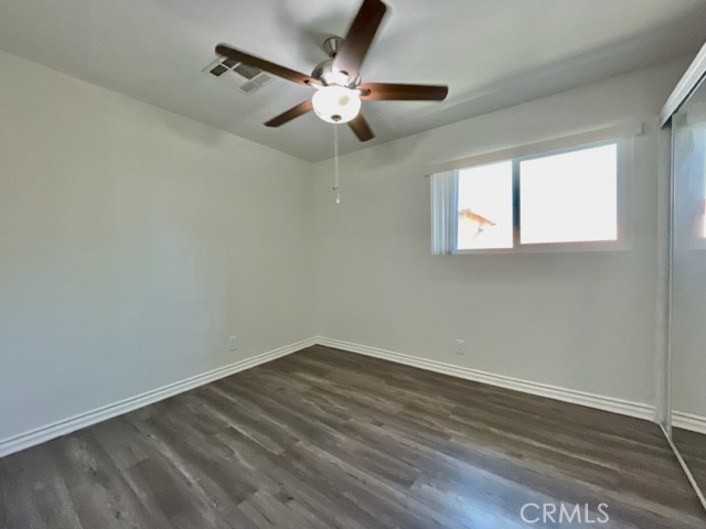 79380 Ave 42, Unit 2 Bermuda Dunes, CA 92203 - Photo 11 of 15 an empty room with wooden floor fan and windows