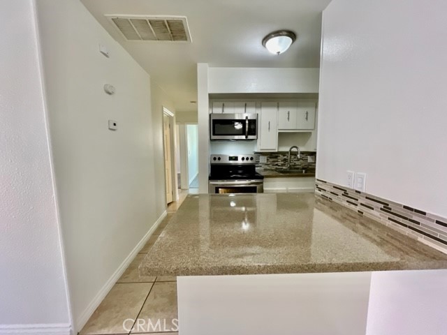 79380 Ave 42, Unit 2 Bermuda Dunes, CA 92203 - Photo 6 of 15 a kitchen with stainless steel appliances granite countertop a refrigerator a stove and a sink