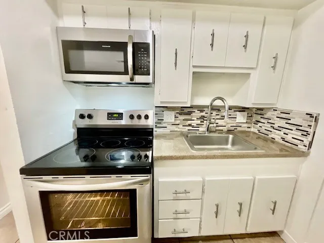 a kitchen with stainless steel appliances granite countertop a stove a microwave and cabinets