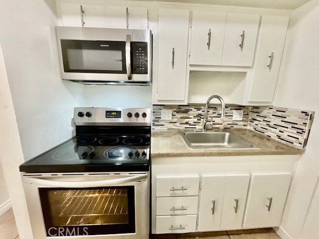 79380 Ave 42, Unit 2 Bermuda Dunes, CA 92203 - Photo 7 of 15 a kitchen with stainless steel appliances granite countertop a stove a microwave and cabinets