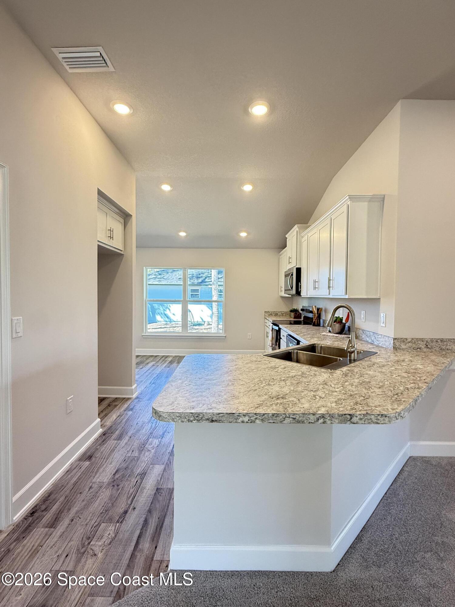 302 Quarry Lane Sebastian, FL 32958 - Photo 15 of 22 a kitchen with kitchen island granite countertop a sink window and a counter top space