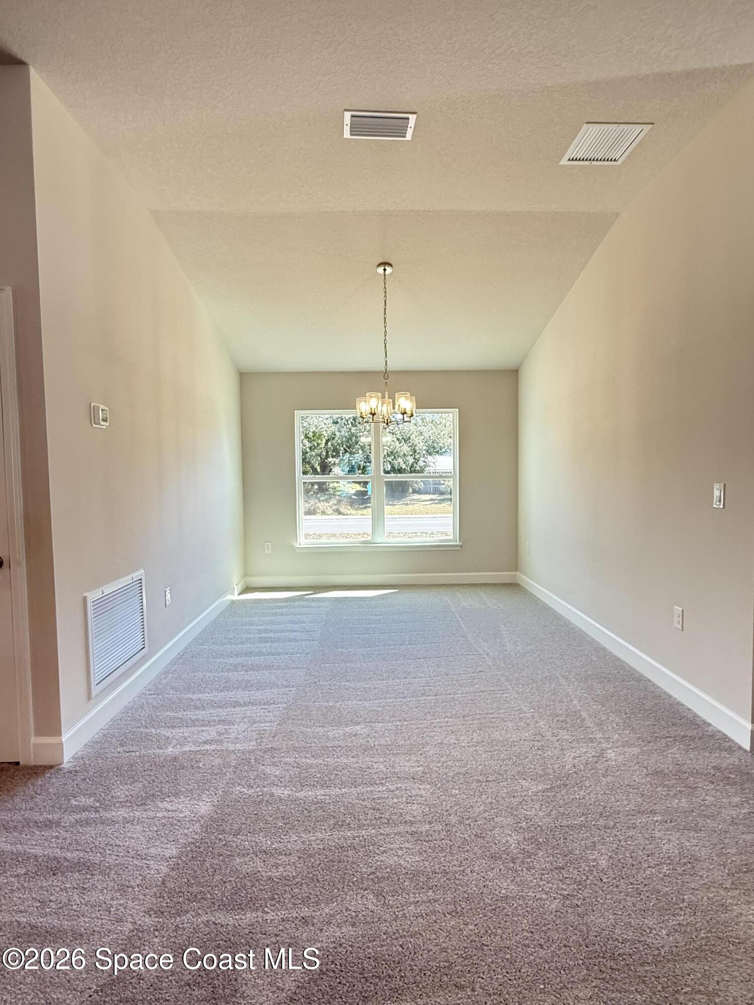 302 Quarry Lane Sebastian, FL 32958 - Photo 17 of 22 an empty room with windows and chandelier fan