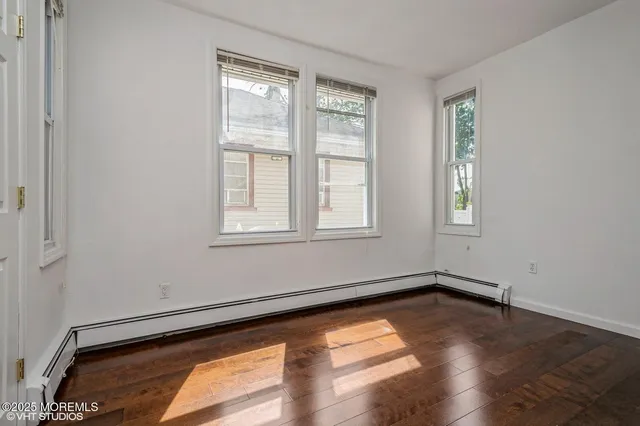 a view of a room with wooden floor and windows