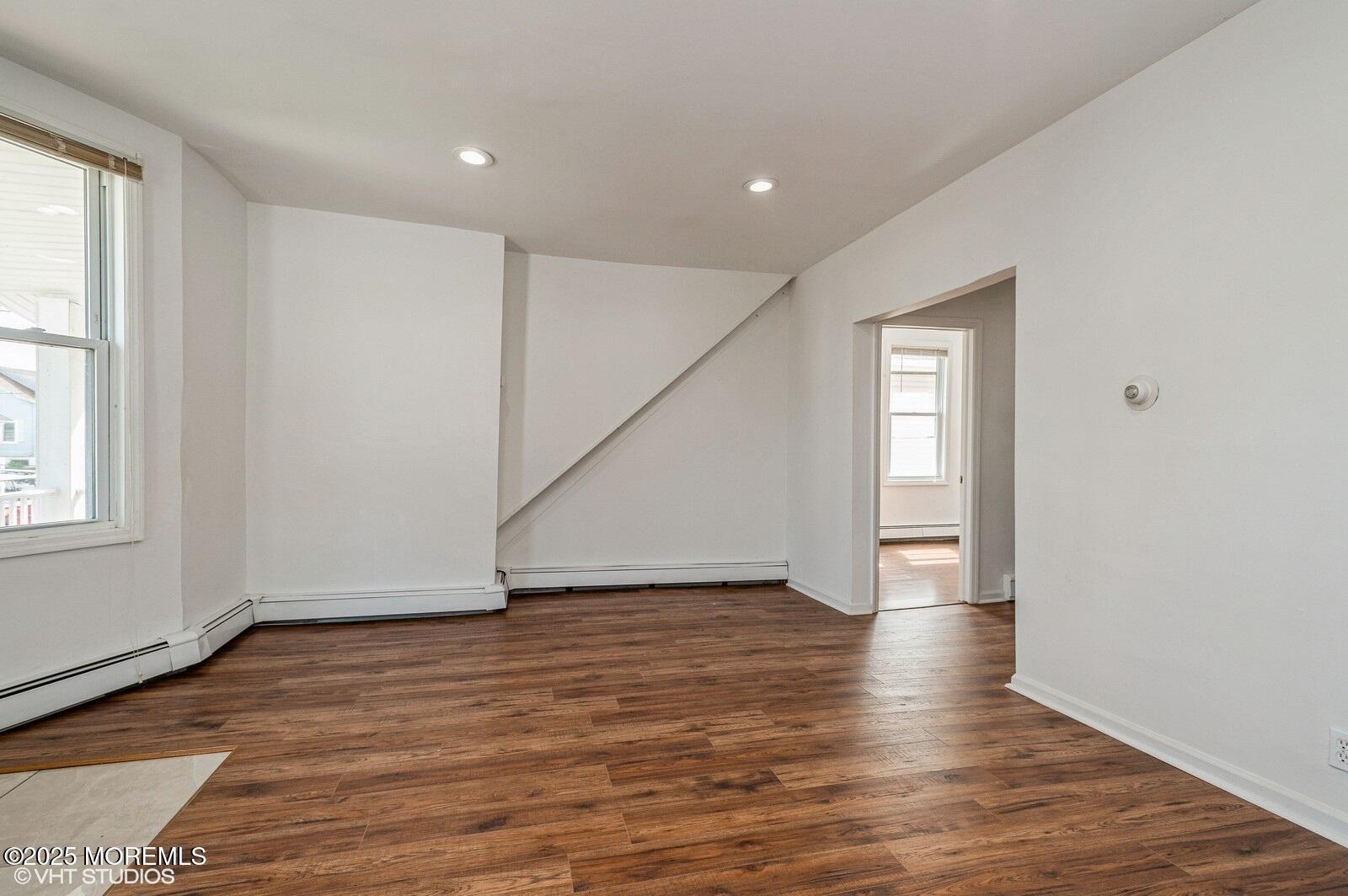 118 Joline Avenue, Unit 1 Long Branch, NJ 07740 - Photo 6 of 21 a view of an empty room with wooden floor and a window