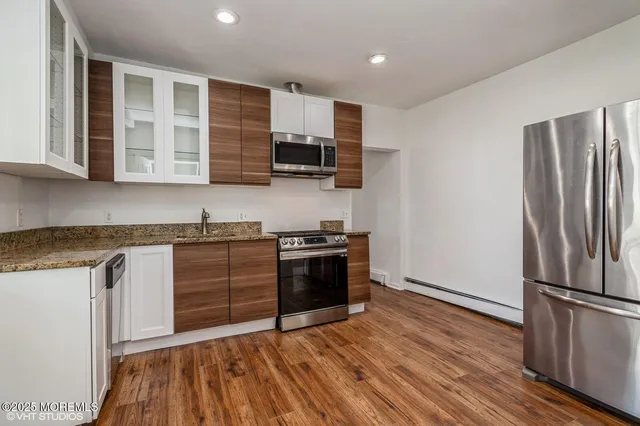 a kitchen with stainless steel appliances granite countertop a refrigerator and a stove top oven