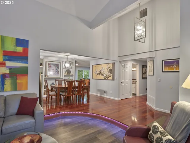 a living room with furniture wooden floor and wall painting