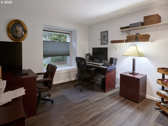 a view of a workspace with furniture and a window