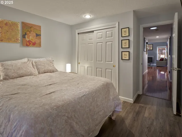 a bedroom with a bed and painting on the wall