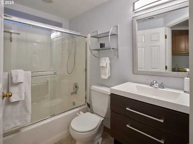 a bathroom with a shower sink vanity mirror and toilet