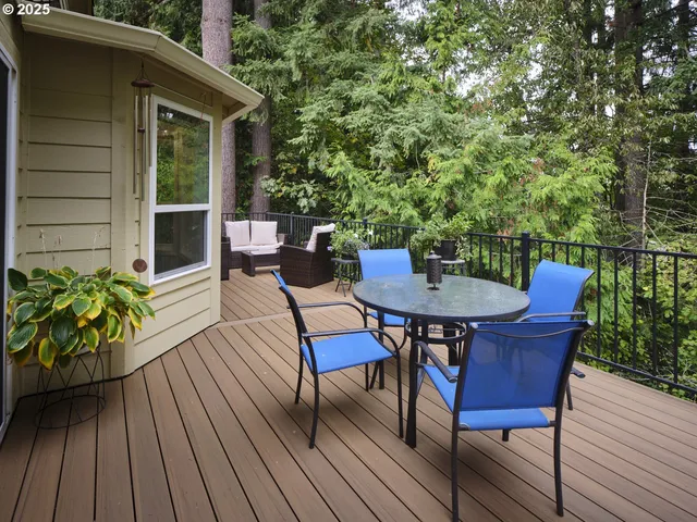 a roof deck with table and chairs and wooden floor
