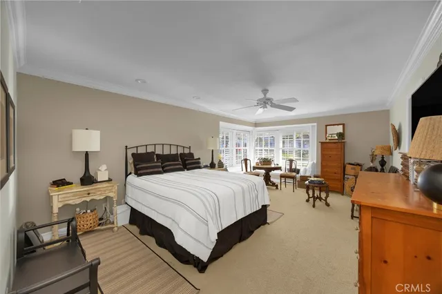 a spacious bedroom with a bed a couch and dresser