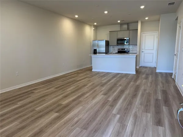 a view of kitchen with wooden floor and electronic appliances