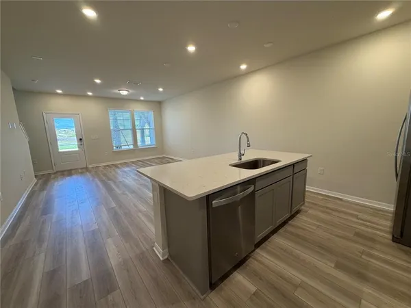 a kitchen with a sink and wooden floor