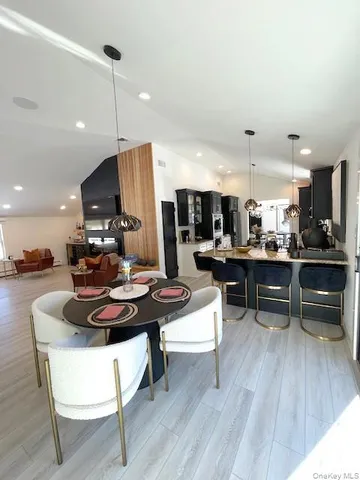 a living room with furniture kitchen view and a wooden floor