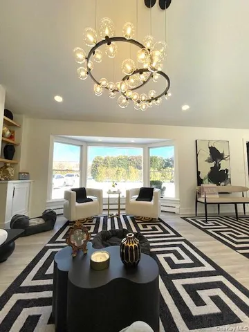 a living room with furniture a flat screen tv and a large window
