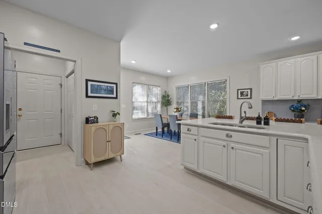 a kitchen with granite countertop white cabinets and stainless steel appliances