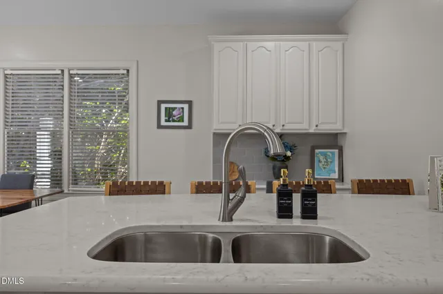 a kitchen with white cabinets and sink