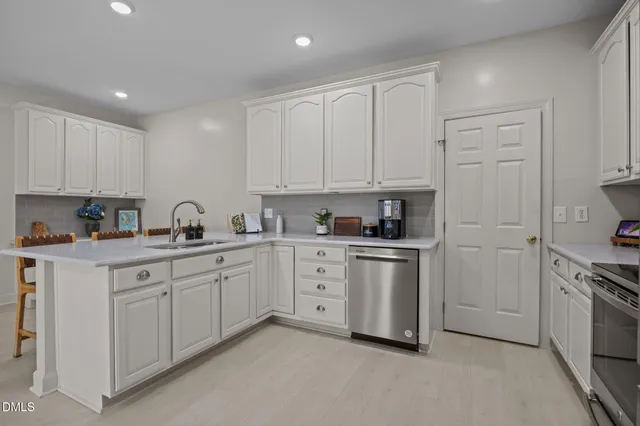 a kitchen with white cabinets stainless steel appliances and sink