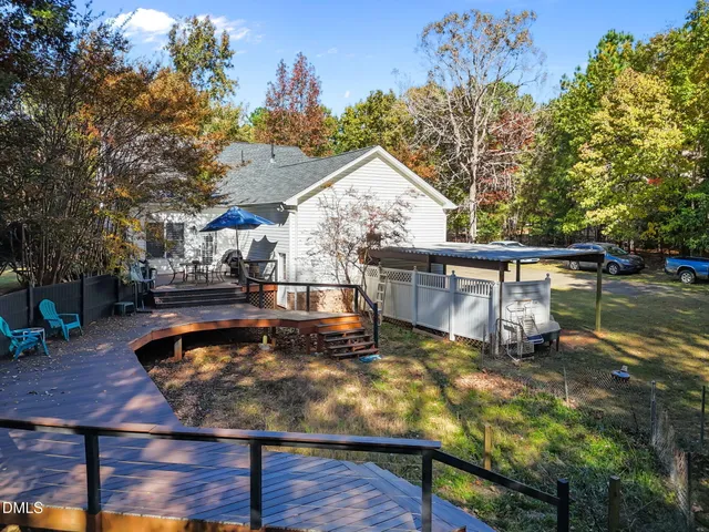 a view of a deck with table and chairs under an umbrella with wooden floor