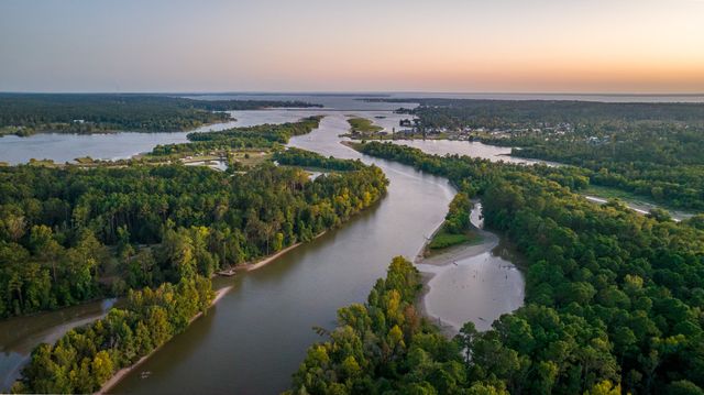 an aerial view of a house with a garden and lake view