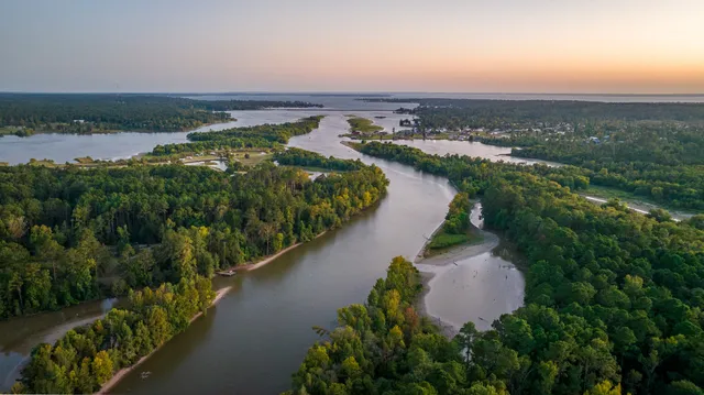 an aerial view of a house with a garden and lake view