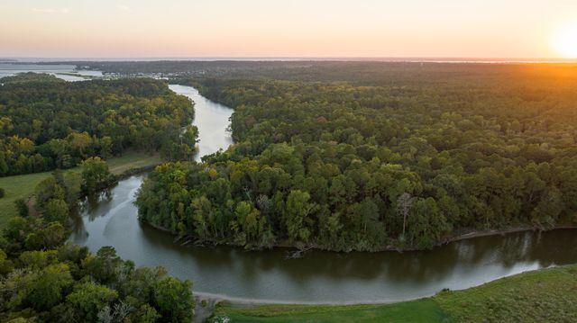 an aerial view of ocean and residential houses with outdoor space