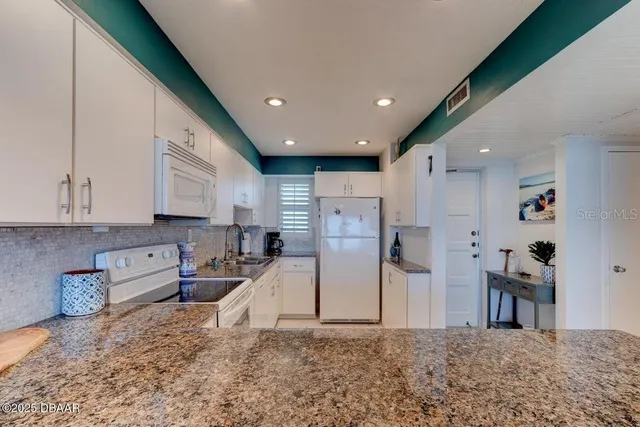 a kitchen with stainless steel appliances granite countertop sink stove and refrigerator