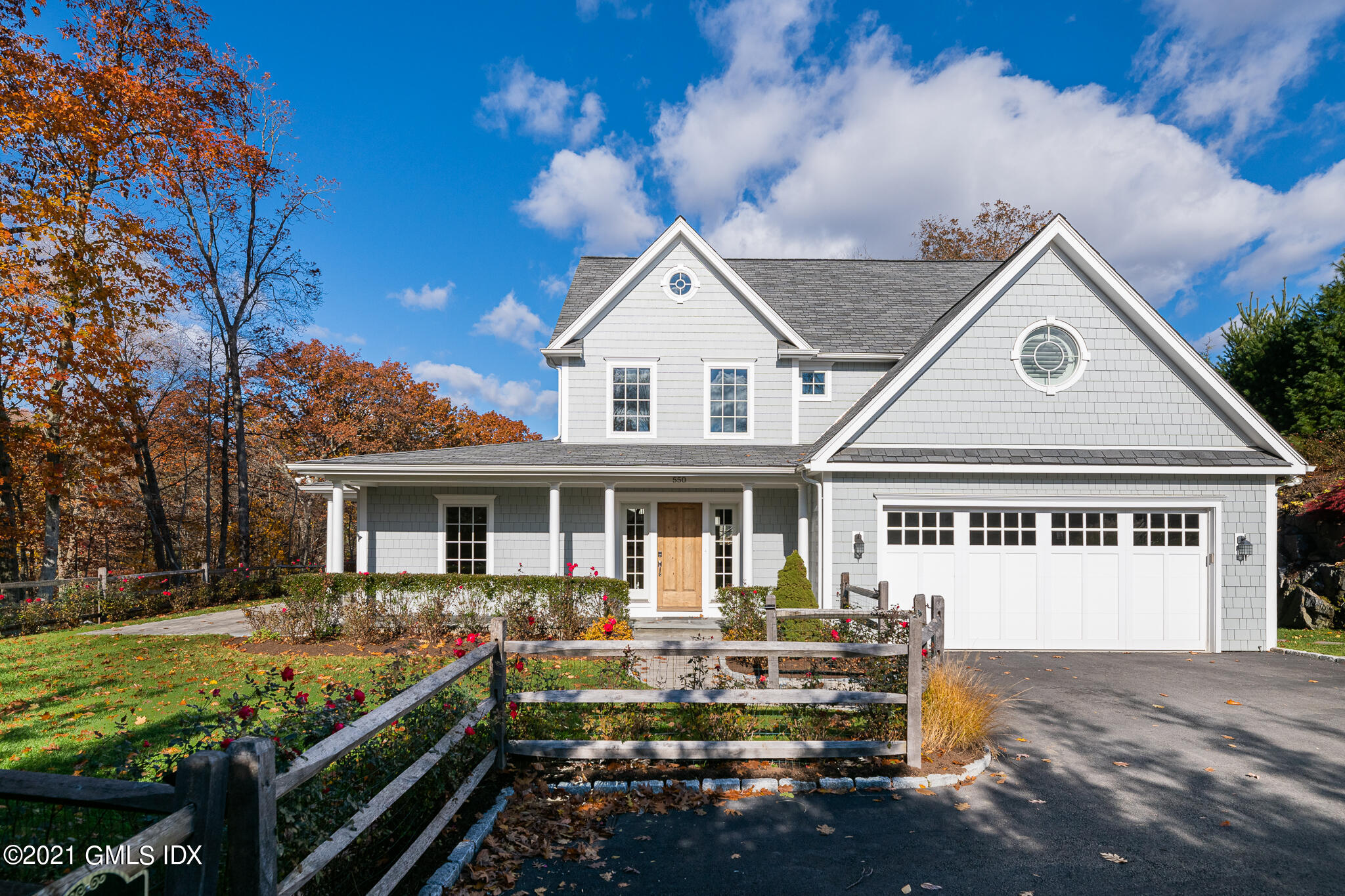 550 River Road Cos Cob, CT 06807 - Photo 2 of 33 a front view of a house with a yard table and chairs
