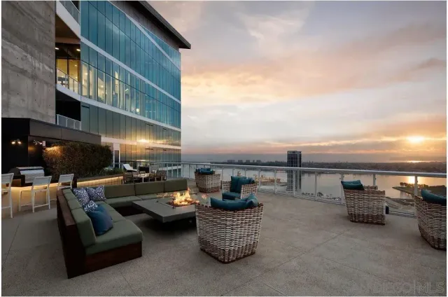 a view of a roof deck with couches and potted plants