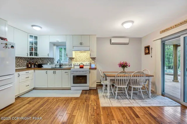 a kitchen with a dining table chairs and white appliances