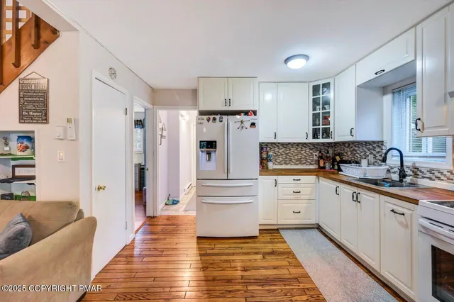 a kitchen with white cabinets and stainless steel appliances