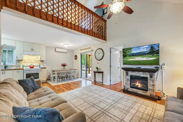 a living room with furniture a flat screen tv and a fireplace