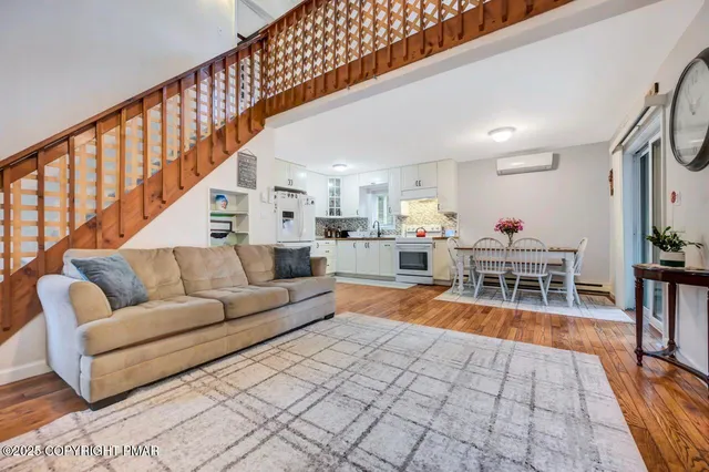 a living room with furniture a dining table and a rug floor