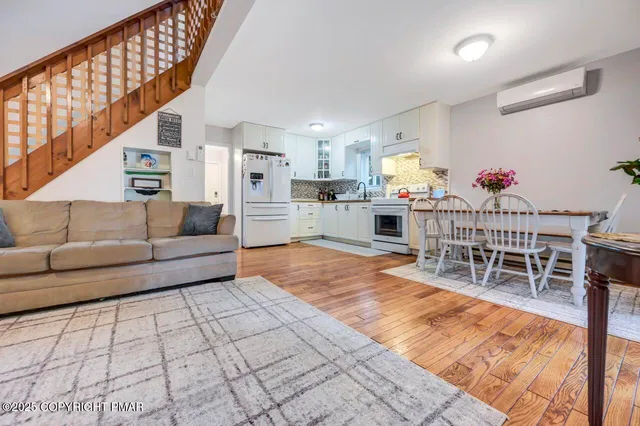 a living room with furniture a dining table and chairs with wooden floor