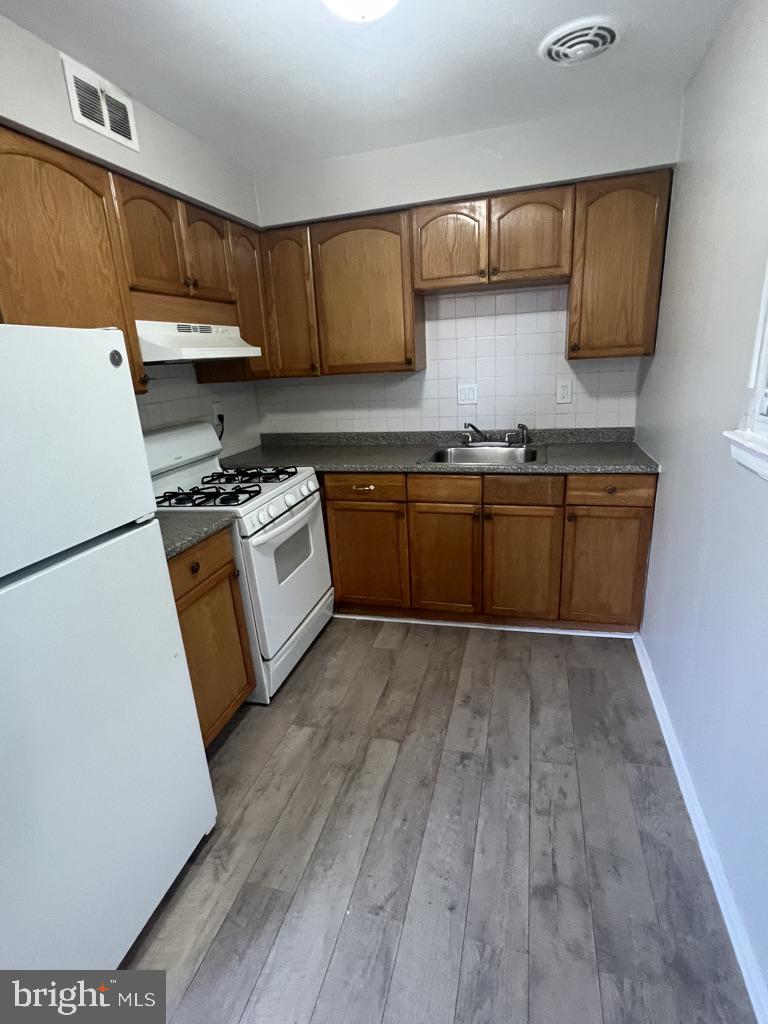 371 Avon Street, Unit 2 Philadelphia, PA 19116 - Photo 8 of 16 a kitchen with granite countertop wooden floors and white stainless steel appliances