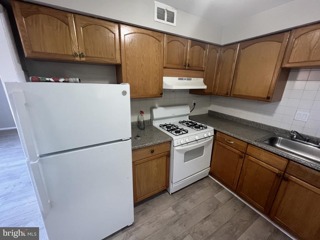 371 Avon Street, Unit 2 Philadelphia, PA 19116 - Photo 9 of 16 a kitchen with cabinets a refrigerator and a stove top oven